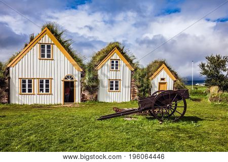 Facade of the farmhouse and ancient rural  wheelbarrow.  Ethnographic Museum-estate Glaumbaer, Iceland. The concept of the historical and cultural tourism 