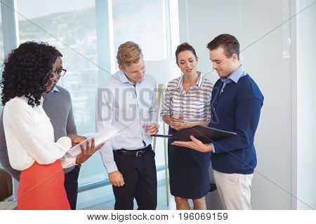 Young business people discussing while standing in office