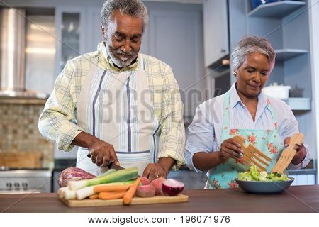 Senior couple preparing food in kitchen at home