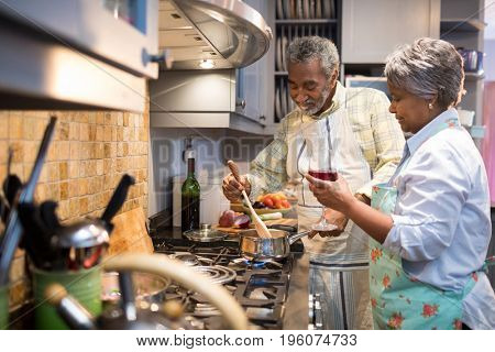 Senior couple preparing food in kitchen at home