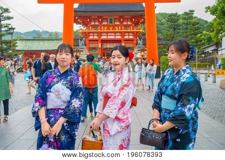 KYOTO JAPAN - NOVEMBER 24, 2016: Young women visiting a fushimi inari temple at rainy day in Kyoto, Japan.
