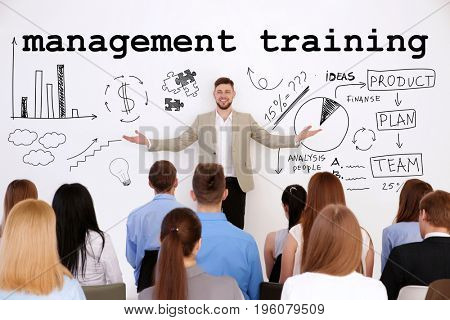 Concept of management training programs. Business trainer with team of managers at conference in office