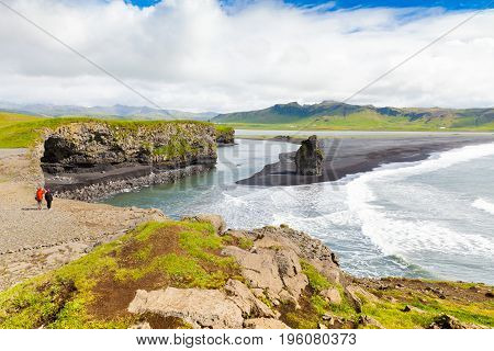 August 2015 Iceland two tourist admire the landscape from the north coast of dyrholaey promontory  vestur kaftafellssysla