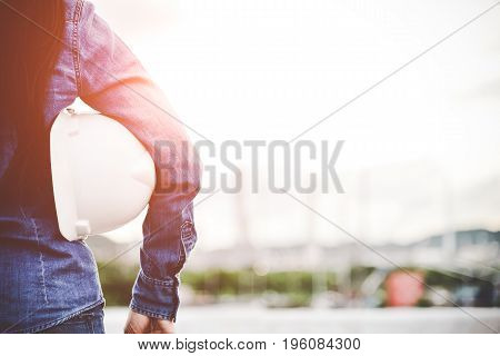 Engineer woman holding white helmt for workers security control at power plant energy industry. Engineer Concept