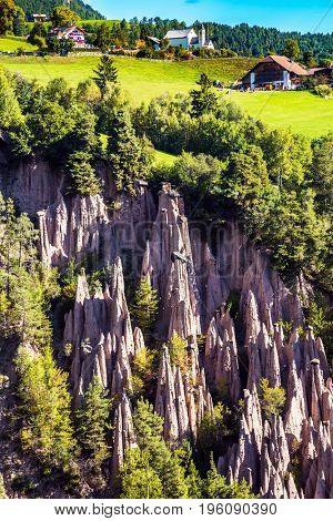  Renon's earth pillars at sunrise. The charming small village in the Dolomites in Tyrol, Italy. The concept of ecological tourism 