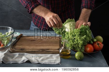 Man cooking vegetables salad in home kitchen. Free space for your object