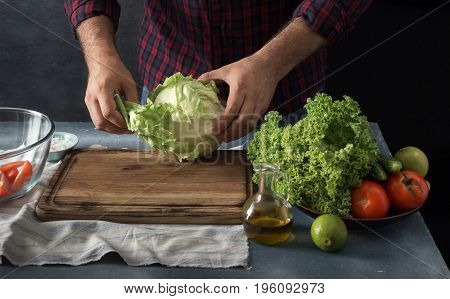 Man preparing vegetables salad in home kitchen. Free space for your object
