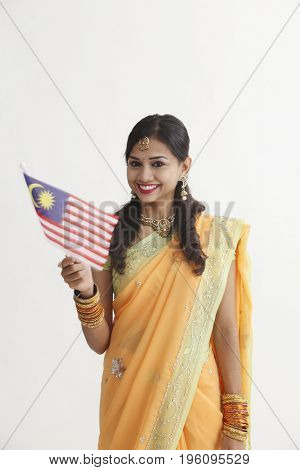 Indian woman in glamorous traditional clothing holding malaysia flag celebration merdeka
