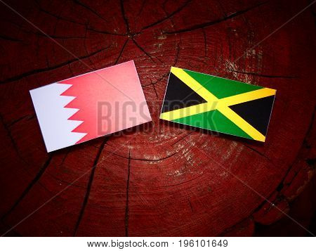 Bahraini Flag With Jamaican Flag On A Tree Stump Isolated