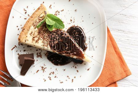 Plate with delicious cheesecake and chocolate, top view