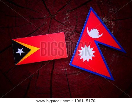 East Timorese Flag With Nepali Flag On A Tree Stump Isolated