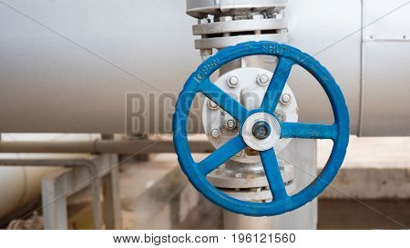 Close up of manual operate ball valve at factory. Pipes and valves industrail equipment.