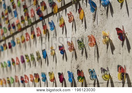 Wall of a house decorated with artificial beautiful butterflies. Art installation