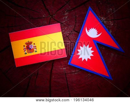 Spanish Flag With Nepali Flag On A Tree Stump Isolated