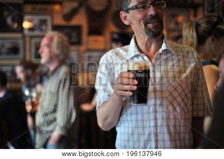 Happy Man Holding A Pint Of Guinness While  Smiling Inside A  Traditional Irish Bar,  Galway, Irelan