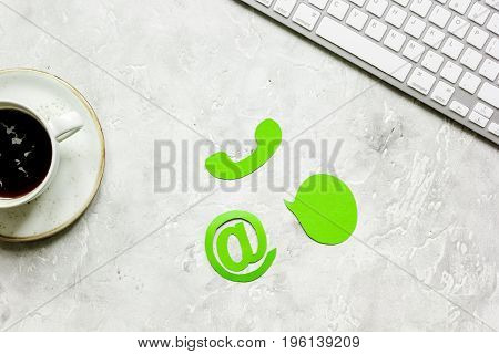 e-mail contact us concept with internet icons and coffee on stone work desk background top view