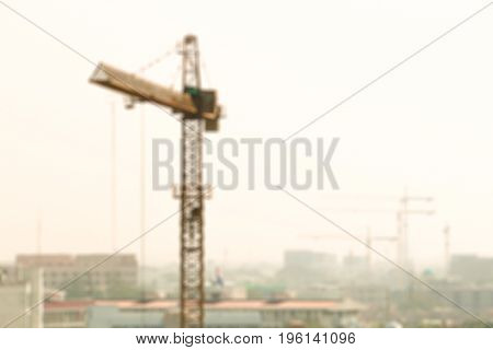 Blurred image of a power crane working the construction in clouddy day background.