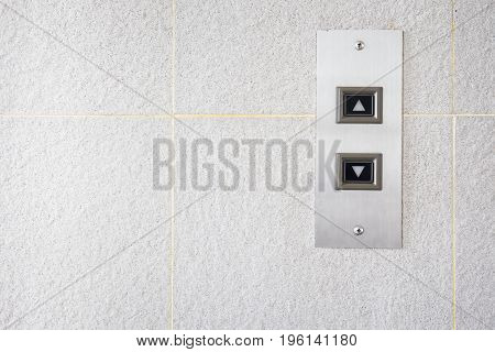 The modern lift button panel on stone tite wall close up background.