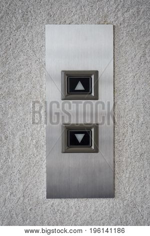 The modern lift button panel on stone tite wall close up background.