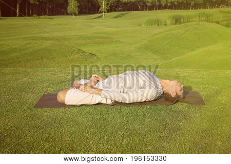 Young man practicing yoga outdoors