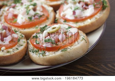 Mini pizza on ready-made buns with tomatoes and sausage