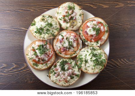 Mini pizza on ready-made buns with tomatoes and sausage