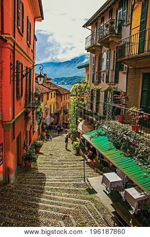Como, Italy - May 06, 2013. View of alley in hillside, buildings with bindweed in Bellagio, a village between the lake and the mountains of Alps. Lombardy region, northern Italy. Retouched photo