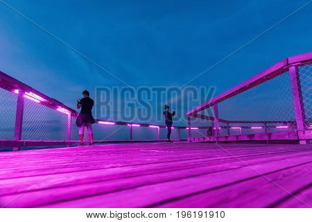 Girl and boy are taking a picture of a cellphone at the top of the observation tower. Treetop Walkway lignting Sightseeing trail in tree crowns. Treetop Walkway in Lipno Czech Republic
