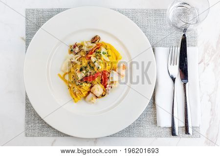 Seafood pasta Spaghetti with Seafood Cocktail on white plate on barbel serface