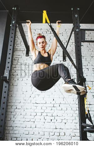 Young fitness woman preparing to do pull ups in pull up bar