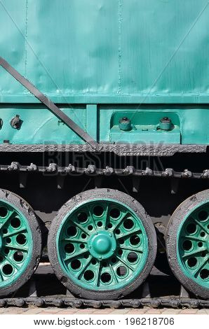 Side View Of The Vehicle On A Caterpillar Track With Black Tracks And Green Wheels And A Side Metal