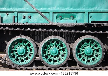 Side View Of The Vehicle On A Caterpillar Track With Black Tracks And Green Wheels And A Side Metal