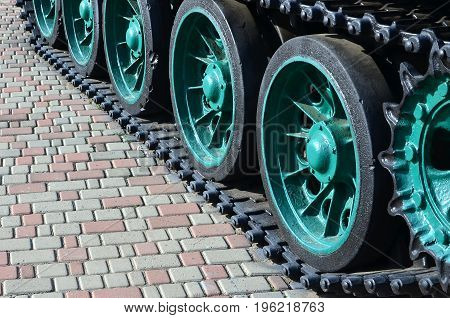 A Military Vehicle On Caterpillar Tracks Stands On A Square Of Paving Stones. Photo Of Green Caterpi