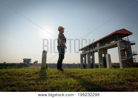 Male Employee Holds Standing While Looking At A Public Floodgate.