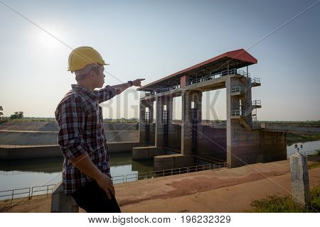 Close Up. Male Employee Standing While Pointing To A Public Floodgate.