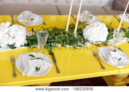 Candles and goblets on a decorated wedding table. yellow green white color. Style lemon