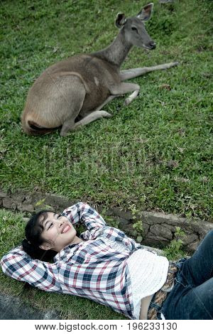 Beautiful smiling Asian woman lying down and emulate deer.