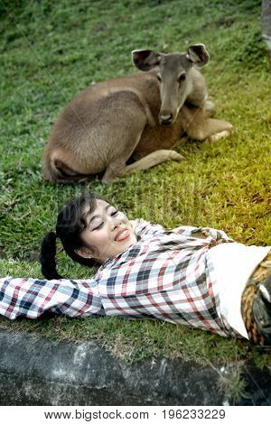 Beautiful smiling Asian woman lying down and emulate deer.