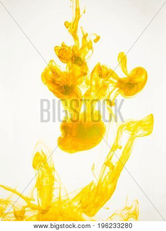 Ink swirl in a water on white background. The paint splash in the water. Soft dissemination a droplets of colored ink in water close-up. Abstract background. Explosion of color splashes acrylic ink.
