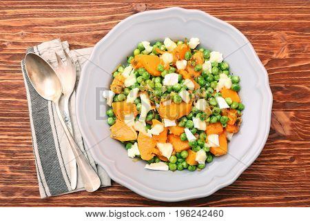 Warm salad with roasted pumpkin, peas and cheese brie. Low fat healthy eating concept.