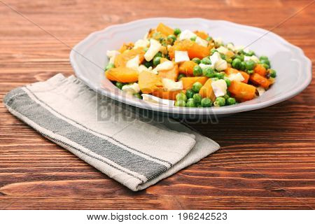 Warm salad with roasted pumpkin, peas and cheese brie. Low fat healthy eating concept.