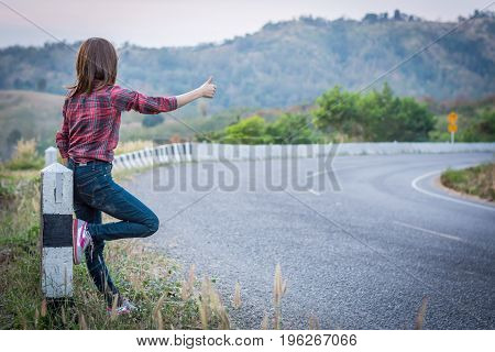 Tourist Hitchhiking Woman Standing On The Road In The Mountains.