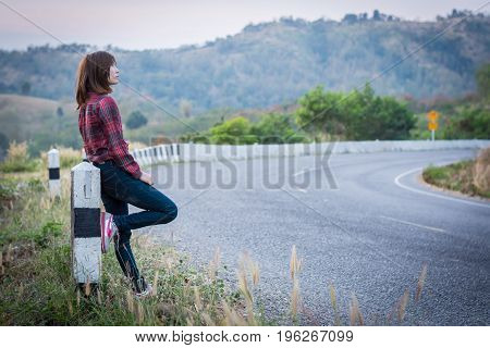 Tourist Hitchhiking Woman Standing On The Road In The Mountains.