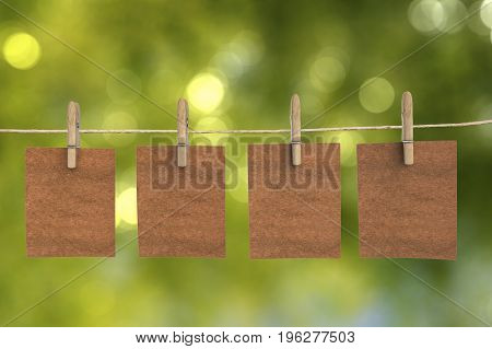 four brown blank papers hanging on clothpins