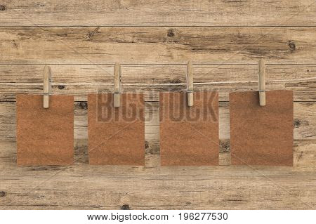 four brown blank papers hanging on clothpins