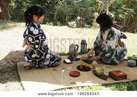 Japanese Women Making Sado Chanoyu Or Japanese Tea Ceremony, Also Called The Way Of Tea At Outdoor