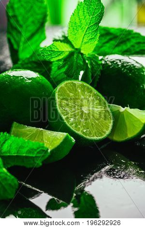 Fresh green mint and lime close-up on a dark green background.