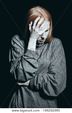 Depressed girl with a headache caused by sorrow