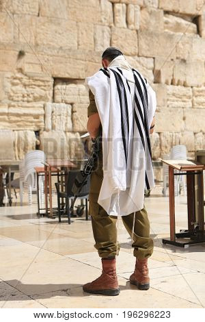 JERUSALEM - September 27: A member of Israel's military visits Jerusalem's Western Wall on September 27 2015 in Jerusalem.