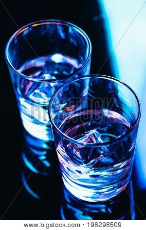 drinking glasses with ice close-up on a dark background.